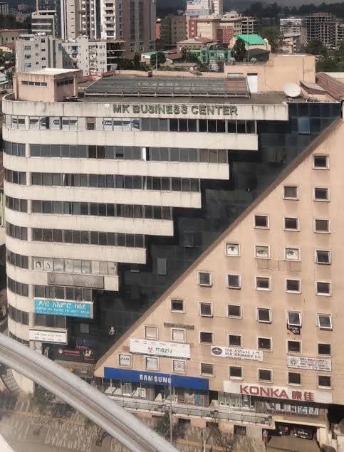 The curved façade of MK Business Center on Mahatma Gandhi Street, Tewodros Square